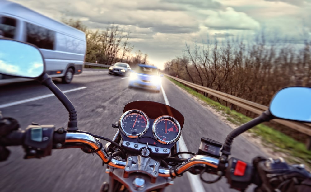 Motorcycle In Front Of Light Vehicle