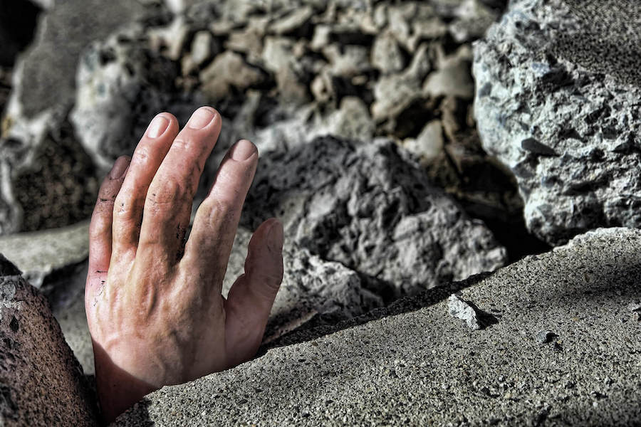 Human Hand Sticking Out Of Rubble