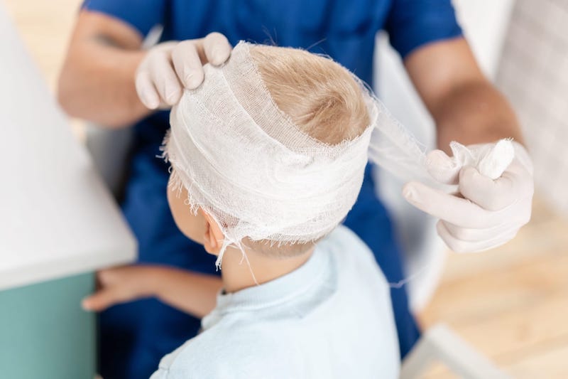 Doctor Bandaging A Childs Head