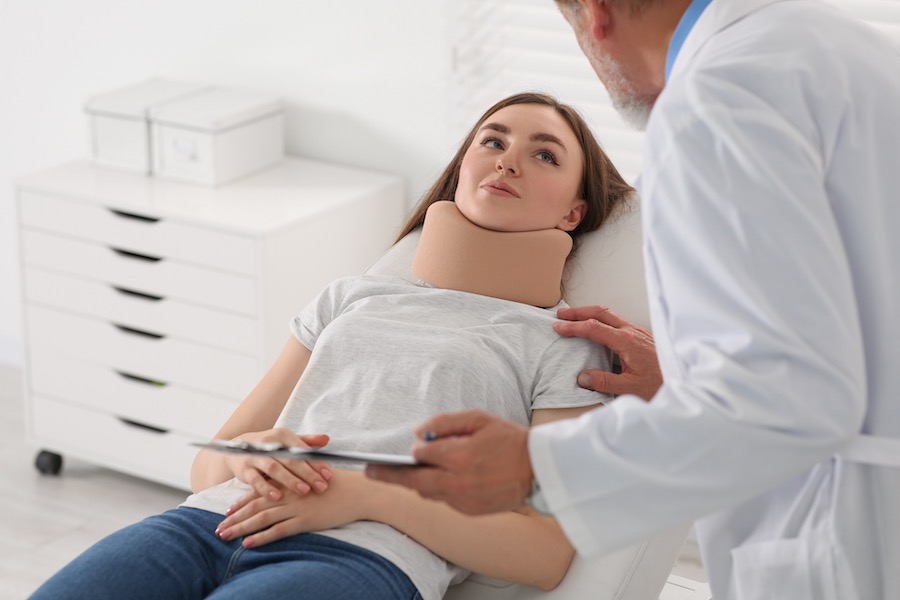 Doctor Checking Up On A Patient With A Neck Cast