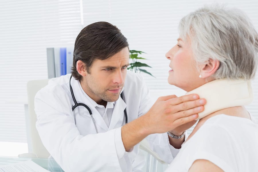 Doctor Examining An Elderly Patients Neck